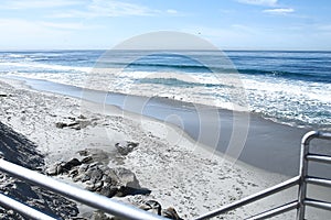 Beautiful view of the oceanfront coastline blue abyss, sandy beach, sunny morning, waves of storm cliff stones rock stone high wa