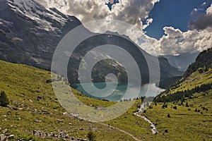 Beautiful view of Oeschinensee, Oeschinen Lake by Kandersteg, Switzerland. Turquoise lake with steep mountains and rocks in ba