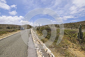 Beautiful view of off-road truck on asphalt road stone desert of natural park on island of Aruba.