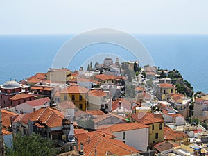 Beautiful view of the old Greek city with red tiled roofs temple and endless blue sea on a hot Sunny summer day