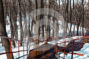 Beautiful view with an old rusty stairway in a snow-covered park