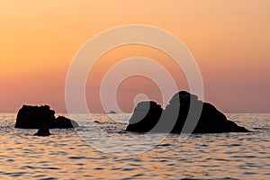 Beautiful view of orange sunset seascape with rocks in Italy. Colorful sunrise landscape