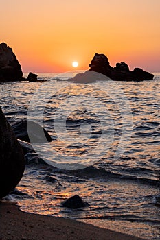 Beautiful view of orange sunset seascape with rocks in Italy. Colorful sunrise landscape