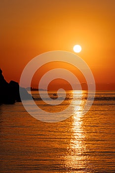 Beautiful view of orange sunset seascape with rocks in Italy. Colorful sunrise landscape