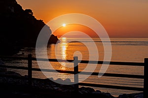 Beautiful view of orange sunset seascape with rocks in Italy. Tropical colourful sunrise landscape. Nature landscape