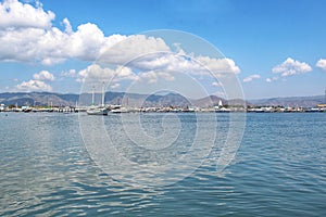 Beautiful View Over the Calm Sea Water Accompanied by Floating Boats Large Mountains with Clear Cloudy Blue Sky Background