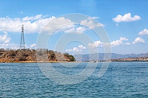 Beautiful View Over the Calm Sea Water Accompanied by Floating Boats Large Mountains with Clear Cloudy Blue Sky Background