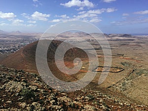 Beautiful view overlooking rusty red desert, distant mountains in Fuerteventura island, Canaries, Spain