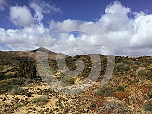 Beautiful view overlooking rusty red desert, distant mountains in Fuerteventura island, Canaries, Spain