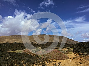 Beautiful view overlooking rusty red desert, distant mountains in Fuerteventura island, Canaries, Spain