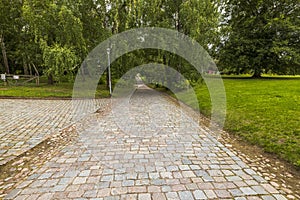 Beautiful view of park with old cobblestone pavement stone walkway background. Cobblestone pavement texture.