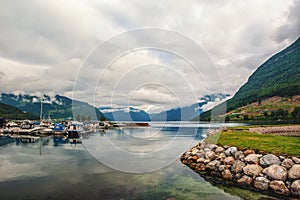 Beautiful view of the Parking of yachts and boats in the Bay of the Norwegian fjord. Mountain view in cloudy, dramatic