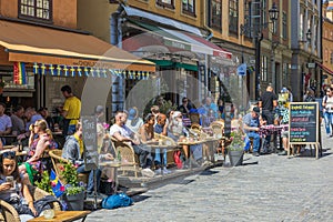 Beautiful view of people in outdoor cafÃ© decorated with Swedish flags. Stockholm.