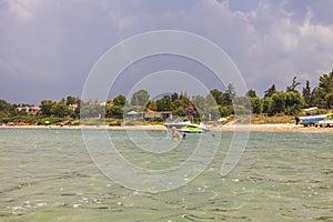 Beautiful view of people swimming in sea and sandy beache with green plants on background. photo