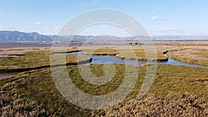 Beautiful view of Prairie fields with blue lake under blue sky with clouds on the horizon