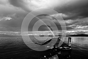 Beautiful view of a rainbow over a pier on a Trasimeno lake Umbria, Italy