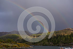 Beautiful view of the rainbow over the river and mountains