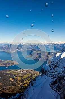 Beautiful view through the rainy window in Mount Pilatus, Lucern, Switzerland. Snowy mountains, Alpnachersee and canton view.