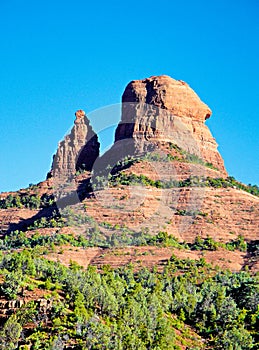 Beautiful view of red rock mountains with juniper trees at the foot in the Northern Arizona deserts