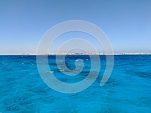 Beautiful view of the Red Sea with a coral reef against the backdrop of Egyptian hotels and blue skies. Hurghada, Egypt. Copy