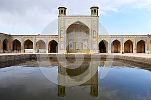 A beautiful view of the reflection of the architectural decorations of an ancient Iranian building on the water. Shiraz, Iran