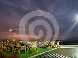 Beautiful view of the restaurant with colourful clouds at evening time with chairs and tables