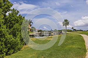 Beautiful view of river and golf course on blue sky with white clouds in background.