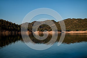 Beautiful view of river water and hills with green trees and blue sky