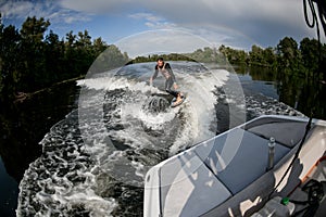 Beautiful view of the river on which along which the man rides on wakesurf. photo