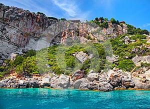 Beautiful view on rock arces arches of Blue caves from sightseeing boat with tourists in blue water of Ionian Sea inside cave, Isl