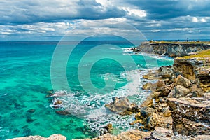 Beautiful view of rocky cliff and turquoise water at sunrise on the the southern part of the Isla Mujeres in Caribbean photo