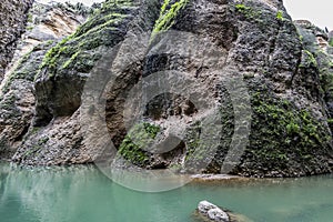 Beautiful view of a rocky slope with green moss and the GuadalevÃ­n river with its turquoise waters