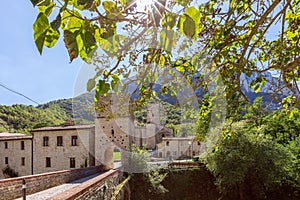 Beautiful view of Roman Catholic abbey San Vittore alle Chiuse from the medieval bridge. Genga, Marche, Italy photo