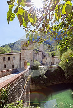 Beautiful view of Roman Catholic abbey San Vittore alle Chiuse from the medieval bridge. Genga, Marche, Italy photo