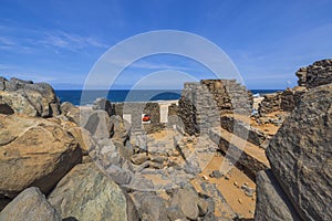 Beautiful view of ruins of Bushiribana with parked cars against backdrop of blue water of Atlantic Ocean. photo