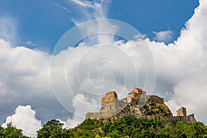 Beautiful view of the Rupea Stronghold on a blue sky with white clouds