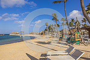 Beautiful view of sandy beach in Caribbean Sea with umbrellas and lounge chairs.