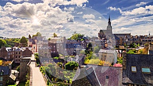 Beautiful view of scenic narrow alley with historic traditional houses and cobbled street in an old town of Dinan with blue sky