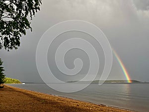 Beautiful view of a sea with a rainbow in the background on a gloomy day