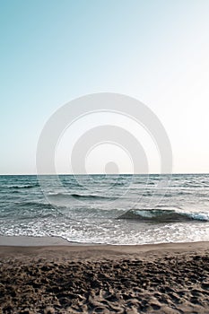 Beautiful view of sea waves splashing on a beach on a sunny day