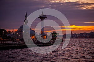 Beautiful view of Semsi Pasa Mosque and Uskudar lighthouse during sunset in Istanbul photo