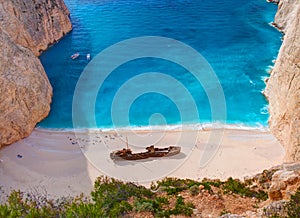 Beautiful view on Shipwreck beach in amazing bay, boats and ships with swimming people in Ionian Sea blue water, Blue Caves shipwr