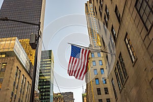 Beautiful view of the skyscraper facade with the United States flag waving proudly.