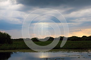 Beautiful view of a small lake under the cloudy sky during sunset