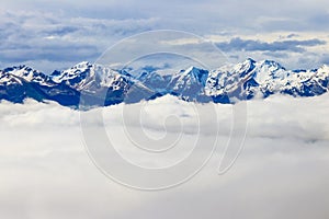 Beautiful view of snow-capped mountains above thick clouds in Bernese Oberland, Switzerland