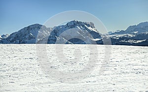 Beautiful view on the snow capped mountains with texture of ski trails and tracks at ski resort.