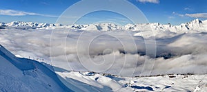 beautiful view on snowy mountain range above white clouds in the French alps