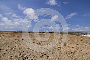 Beautiful view of stone desert on island of Aruba against blue sky with white clouds background.