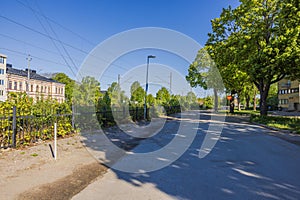 Beautiful view of street green trees, a divider along the railway tracks, and residential houses.