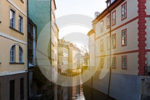 Beautiful view of a street with old water mill in a canal in center of Prague at sunrise. Czechia